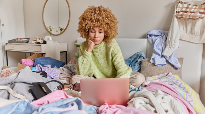 Woman sitting on unorganised bed