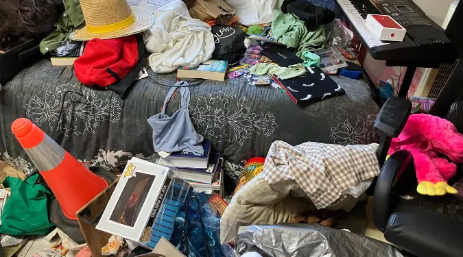Dirty bed with full of cloths and garbage