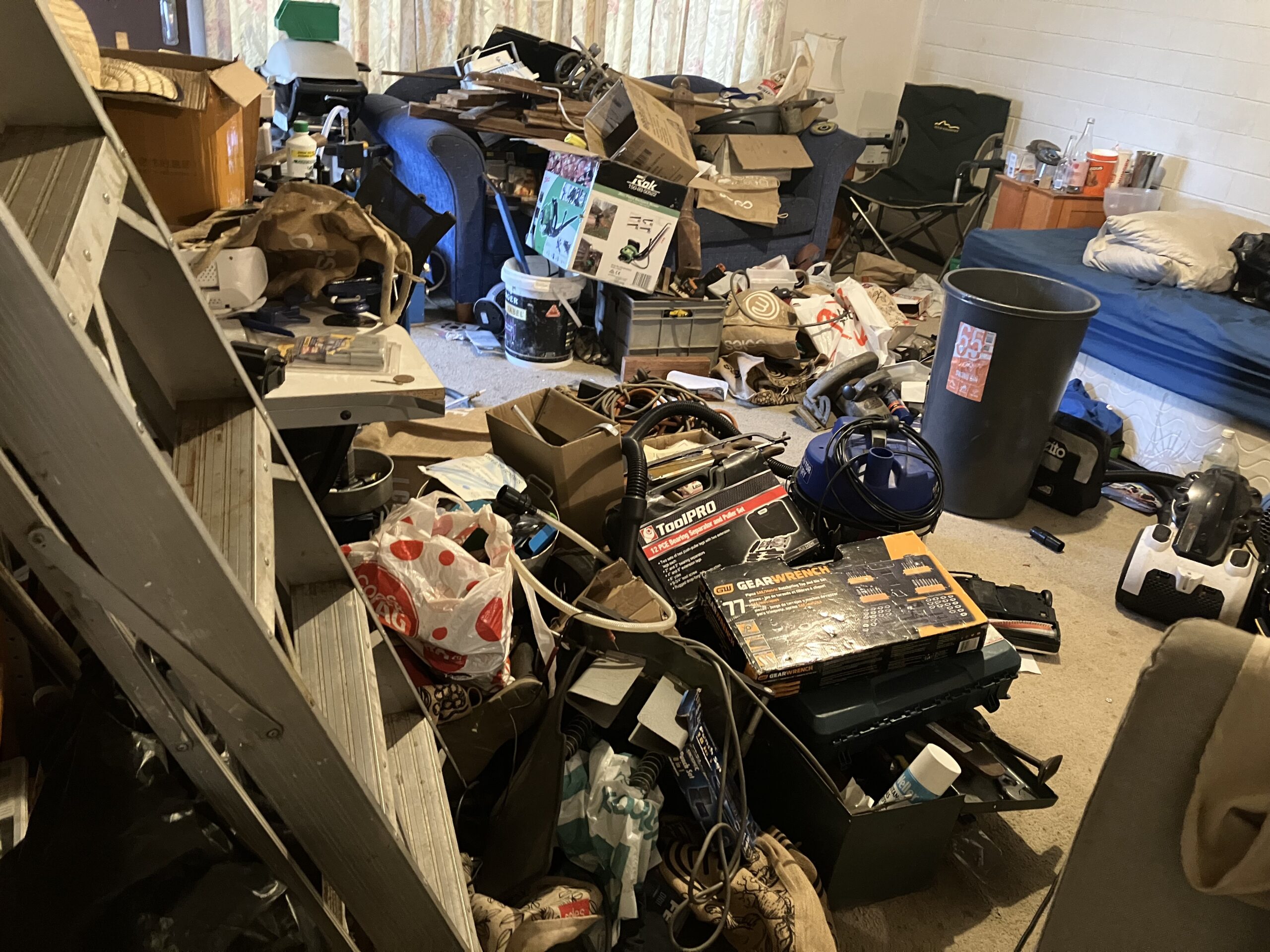 Overwhelmed person surrounded by mess, representing early signs of hoarding or clutter issues.