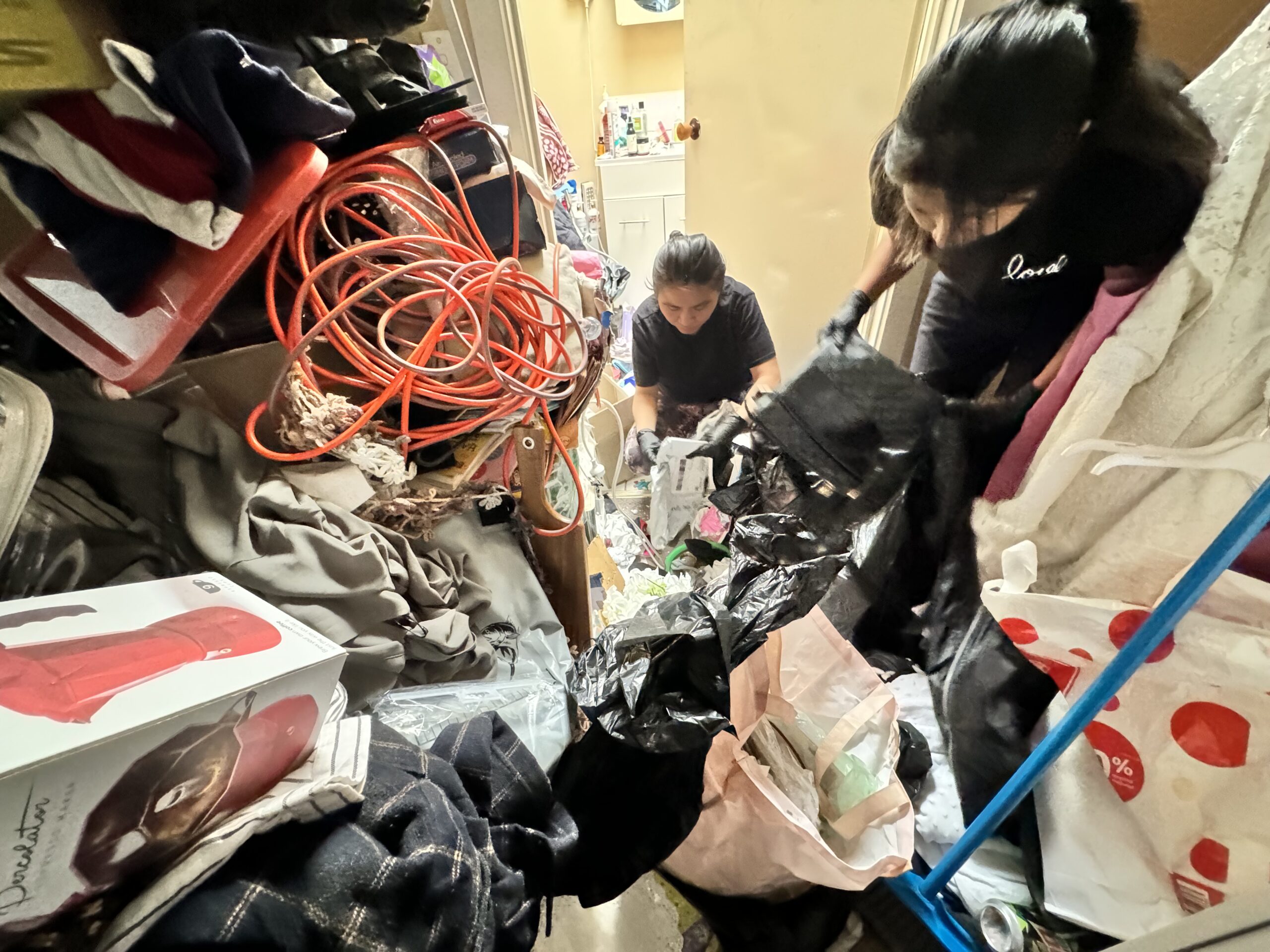Support worker helping a client sort through household clutter before eviction.