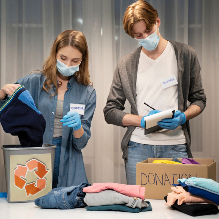 Volunteers sort and organise donated clothing, demonstrating practical NDIS Decluttering and household organisation support.